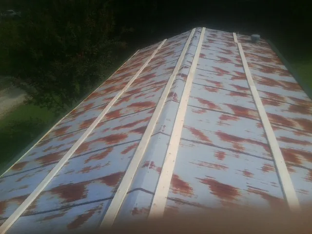Rusted metal roof panels with new wood purlins before replacement — Storm Damage Roof Repair in Grover by Roofing Brothers
